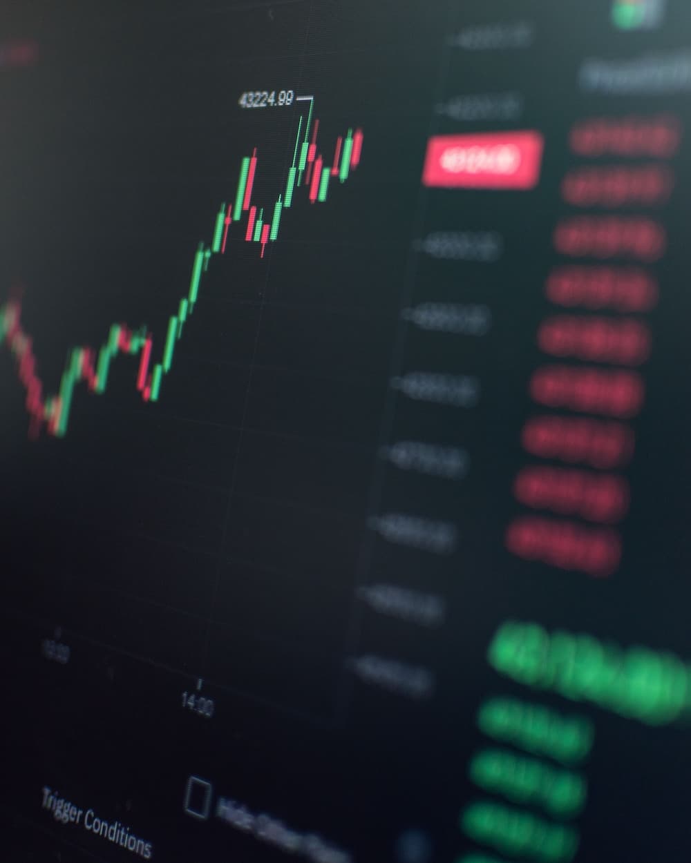 Trading screens reflecting on a glass desk